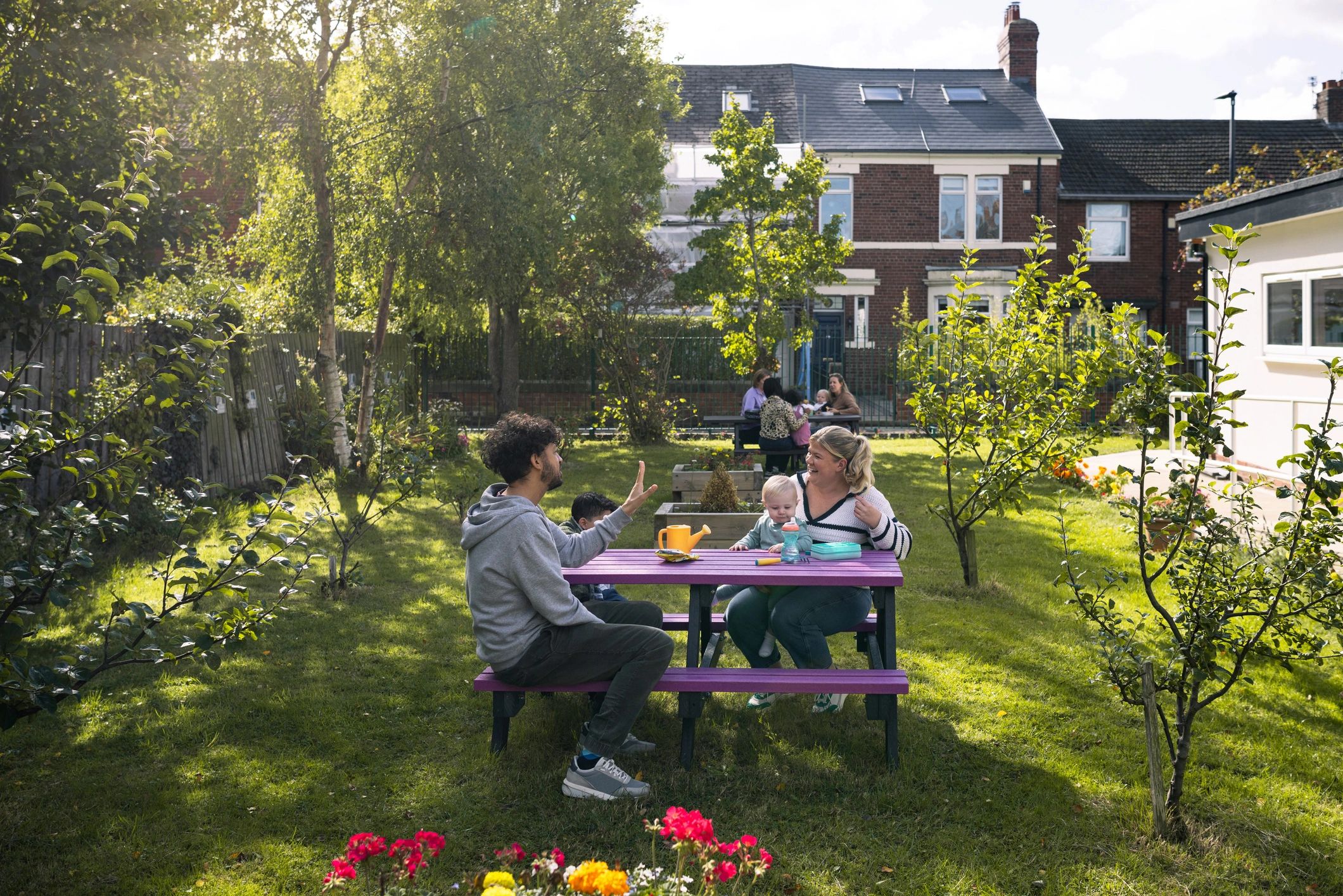 Families and friends gathering outdoors in a community garden